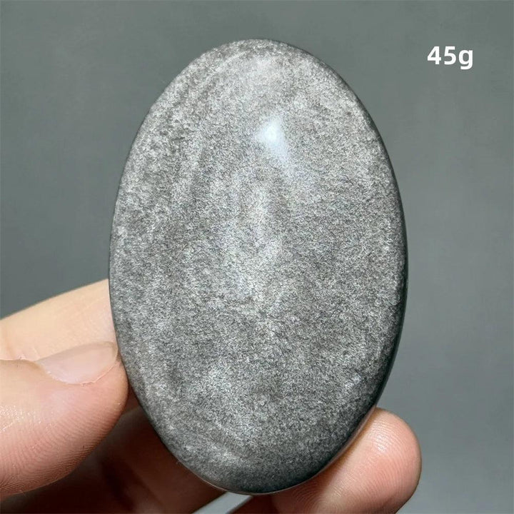 Polished 45g Silver Sheen Obsidian palm stone with a glossy black surface and shimmering silver reflection for grounding.