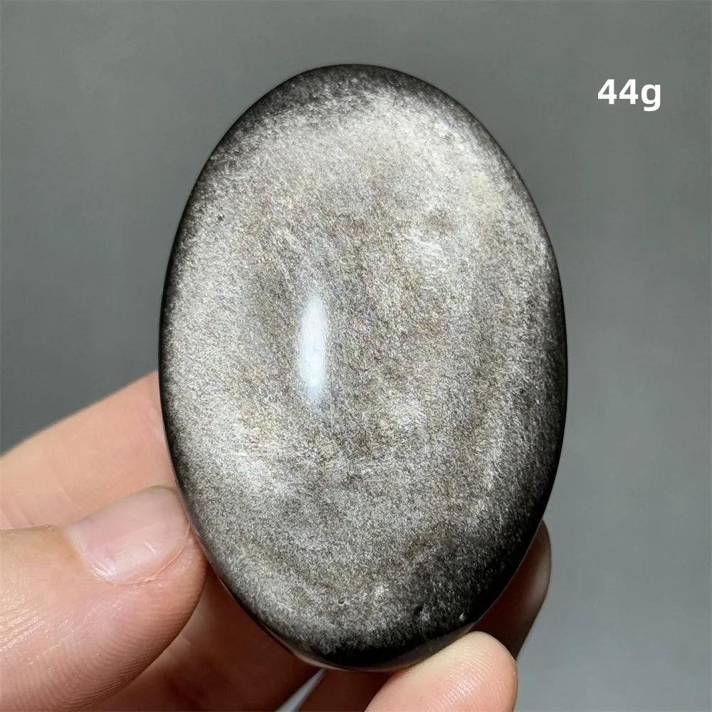 Polished 44g silver sheen obsidian palm stone with a glossy black surface and reflective silvery shimmer for grounding.