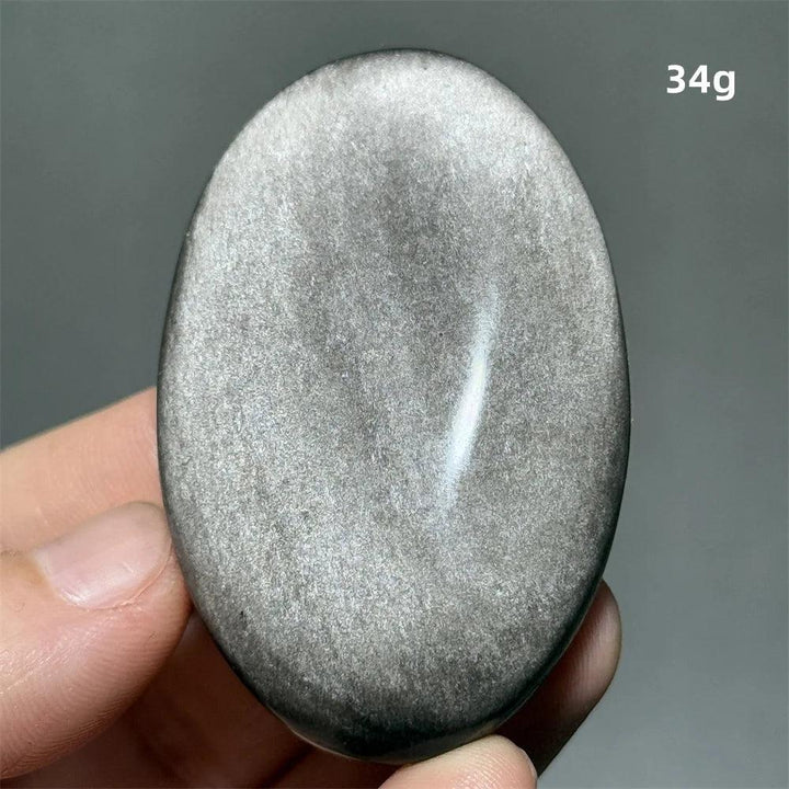 Polished 34g Silver Sheen Obsidian palm stone with a glossy black surface and reflective silvery shimmer for grounding.