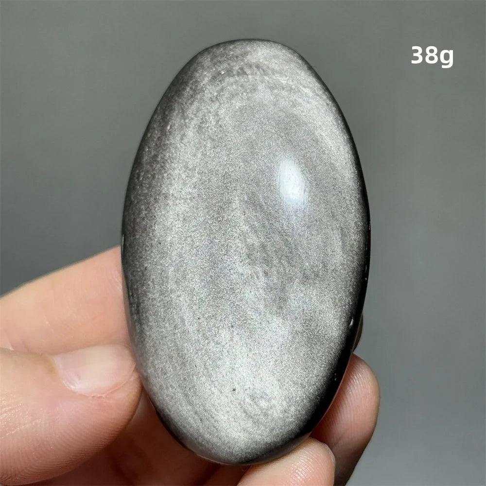 Polished 38g Silver Sheen Obsidian palm stone with a glossy black surface and reflective silvery shimmer for grounding.