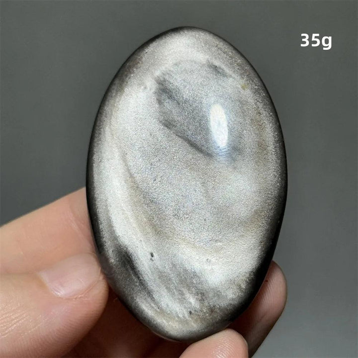 Polished 35g Silver Sheen Obsidian palm stone with a glossy black surface and reflective, shimmering silver highlights.