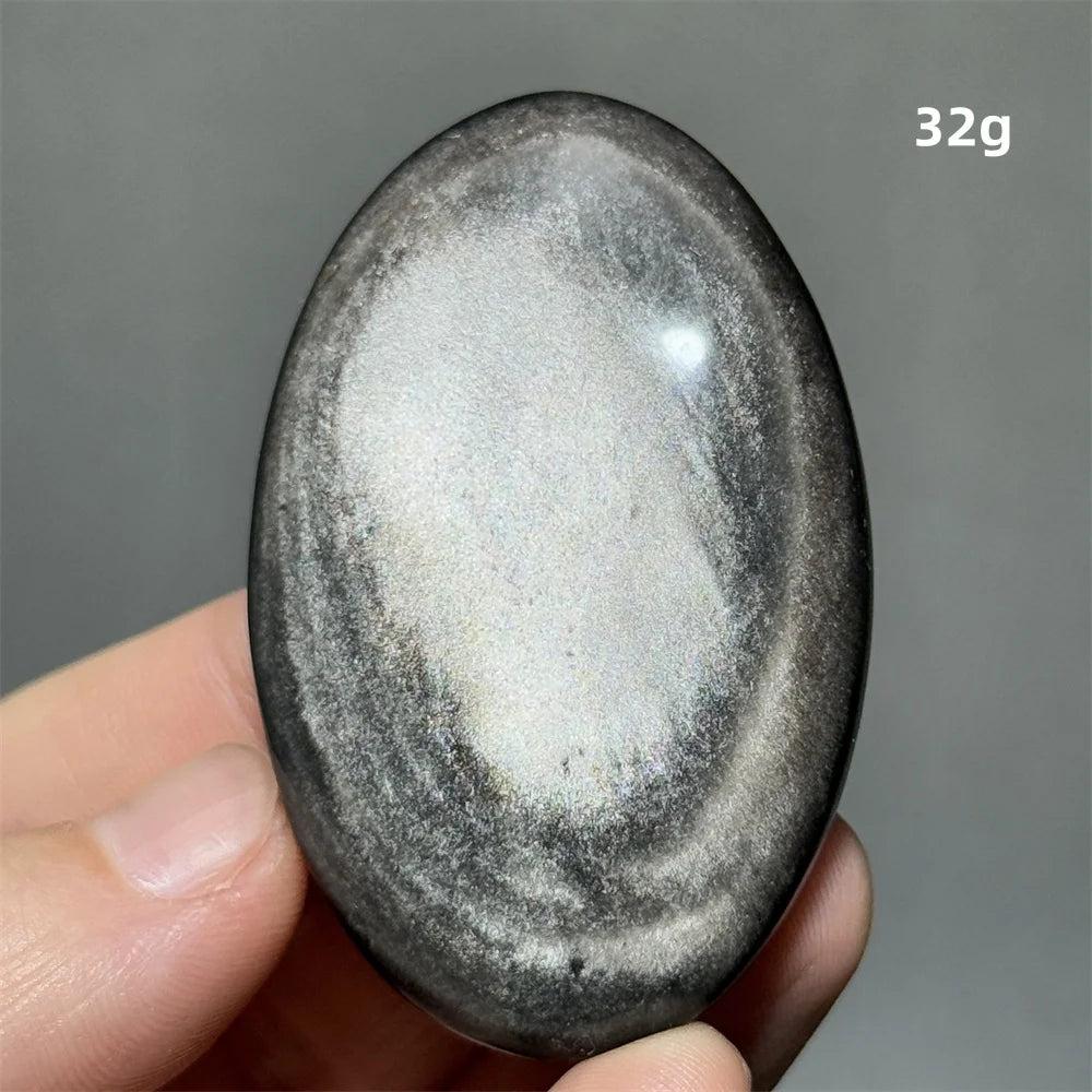 Polished 32g Silver Sheen Obsidian palm stone with a glossy black surface and reflective silvery shimmer for grounding.