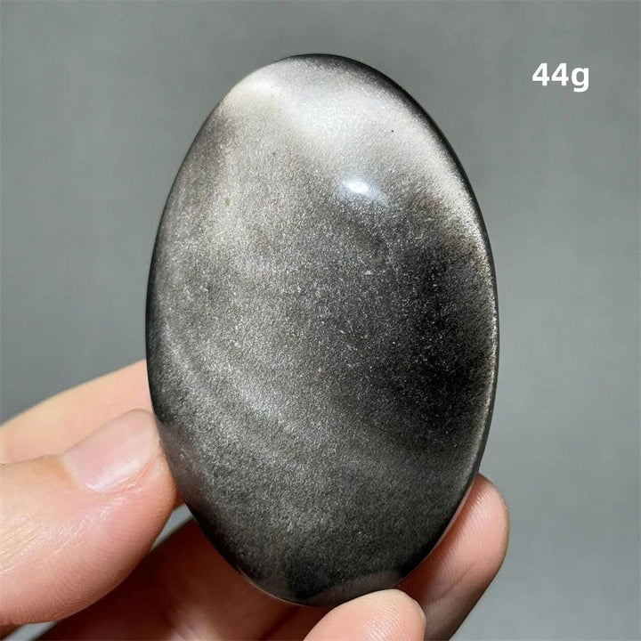 Polished 44g silver sheen obsidian palm stone with a glossy black surface and reflective silvery shimmer for grounding.
