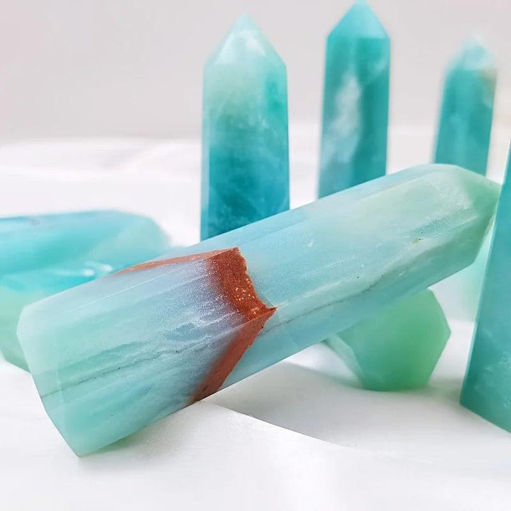 Polished sky blue quartz crystal column with a natural brown band, ideal for healing and home decor.