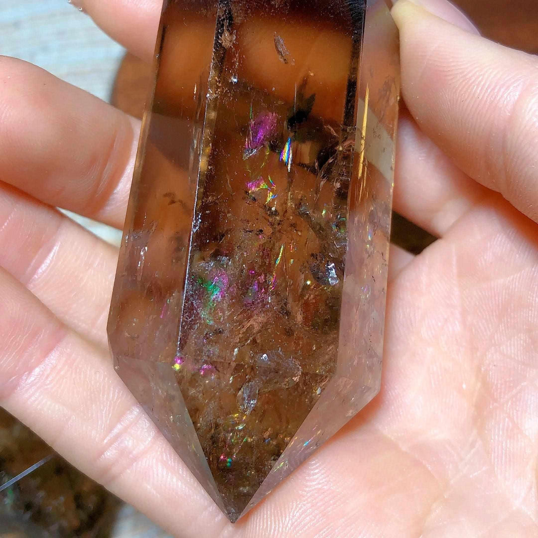 Smoky quartz double point crystal featuring deep brown tones and vibrant natural rainbow flash inclusions for meditation.