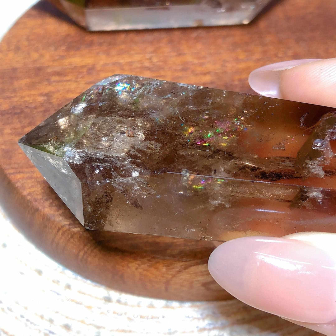 Smoky quartz double point crystal featuring deep brown tones and vibrant natural rainbow flash inclusions for meditation.