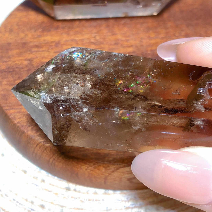 Smoky quartz double point crystal featuring deep brown tones and vibrant natural rainbow flash inclusions for meditation.
