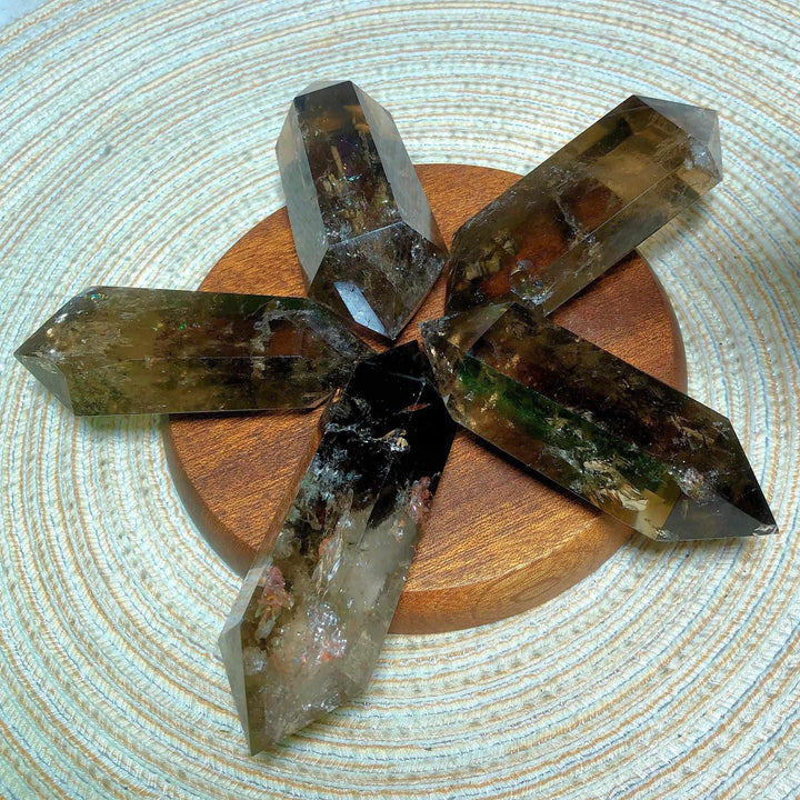 Smoky quartz double point crystals with rainbow inclusions arranged in a star pattern for meditation and energy work.