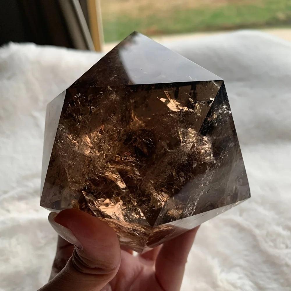 Polished, dark brown smoky quartz crystal freeform, held in hand, showcasing its grounding energy.