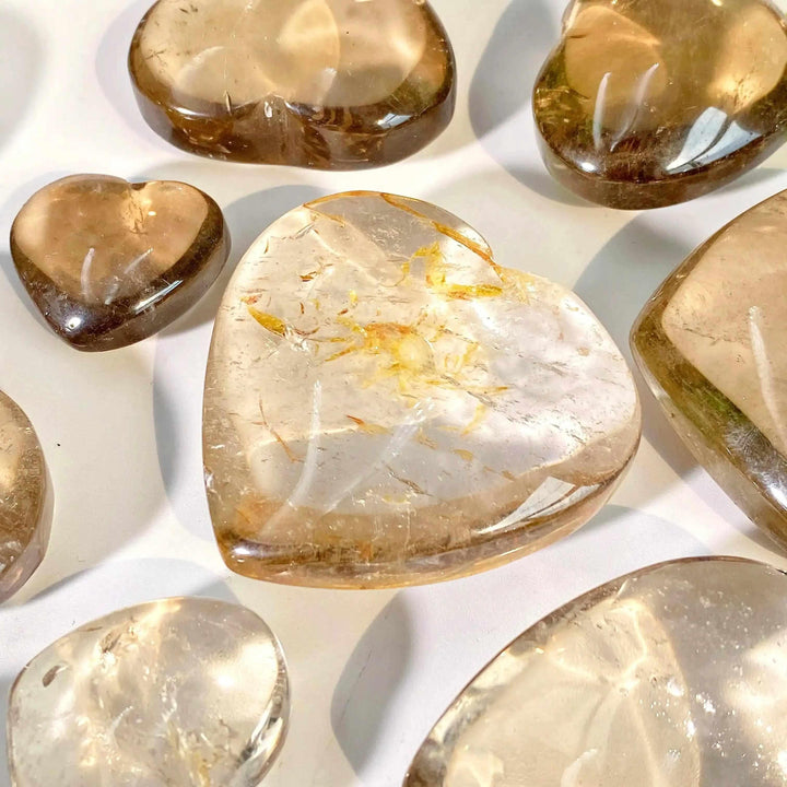 Polished smoky quartz hearts in translucent brown and gray tones, perfect for grounding and Root Chakra healing.