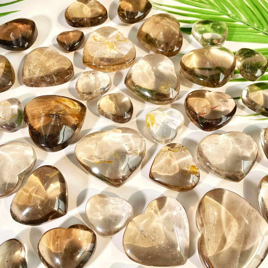 Polished smoky quartz hearts in translucent brown and gray, perfect for grounding and Root Chakra healing.