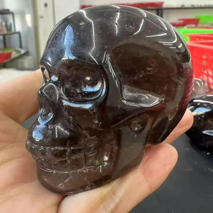 Hand-carved smoky quartz skull, a grounding crystal with translucent brown tones and a polished, reflective finish.