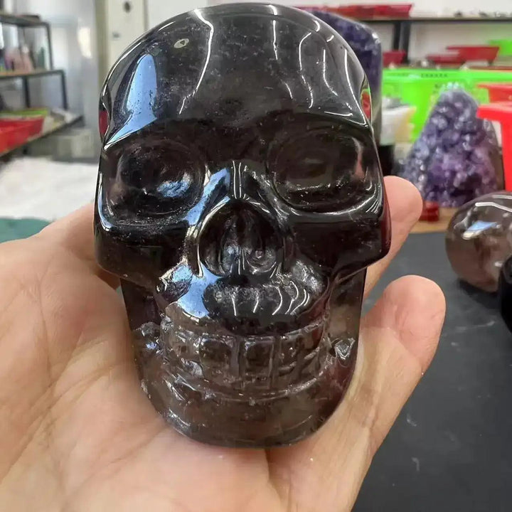 Hand-carved smoky quartz skull, a polished, translucent grounding crystal for protection and root chakra balance.