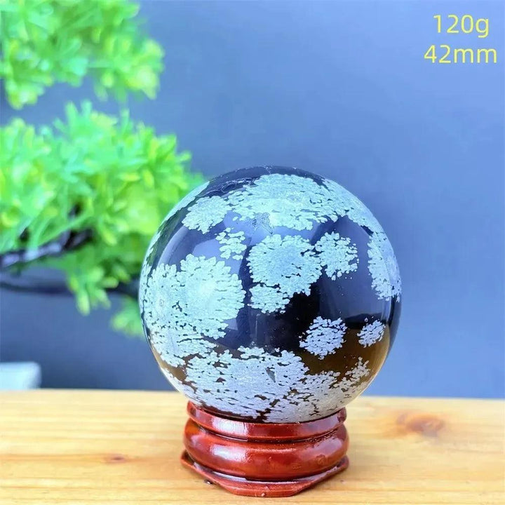 Snowflake Obsidian Sphere with White Snowflake Patterns. Polished black volcanic crystal for grounding and protection.