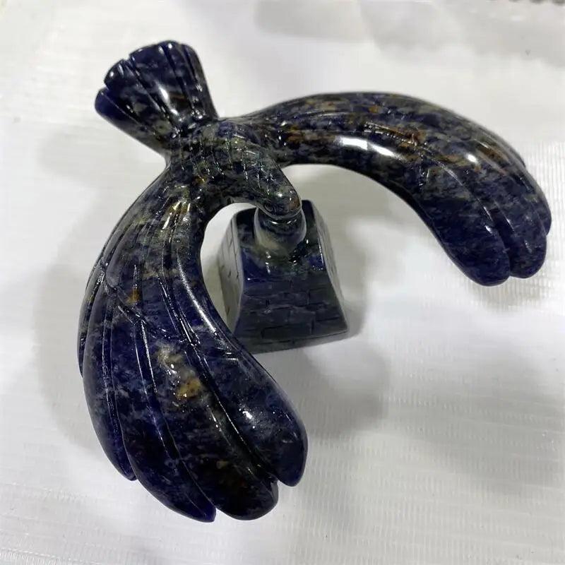 Sodalite crystal eagle statue balanced on a rotating pyramid base, featuring deep blue stone with white calcite veining.