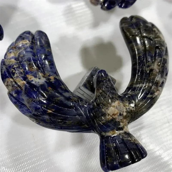 Sodalite crystal eagle statue with deep blue and white veining, balanced on a rotating pyramid base for mental clarity.