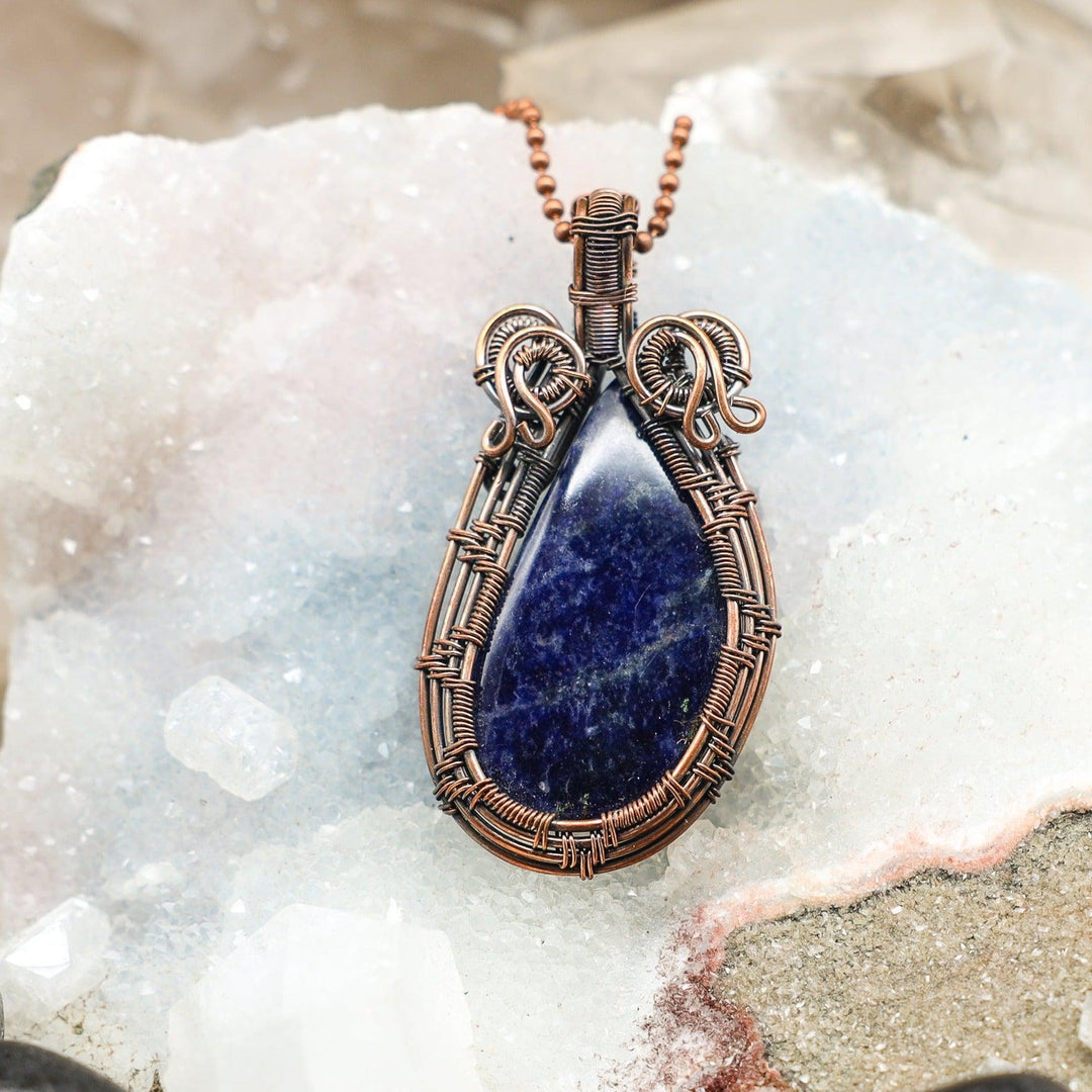 Sodalite Wire Wrap Crystal Pendant: Vivid royal blue sodalite in handcrafted copper wire, promoting logic and truth.