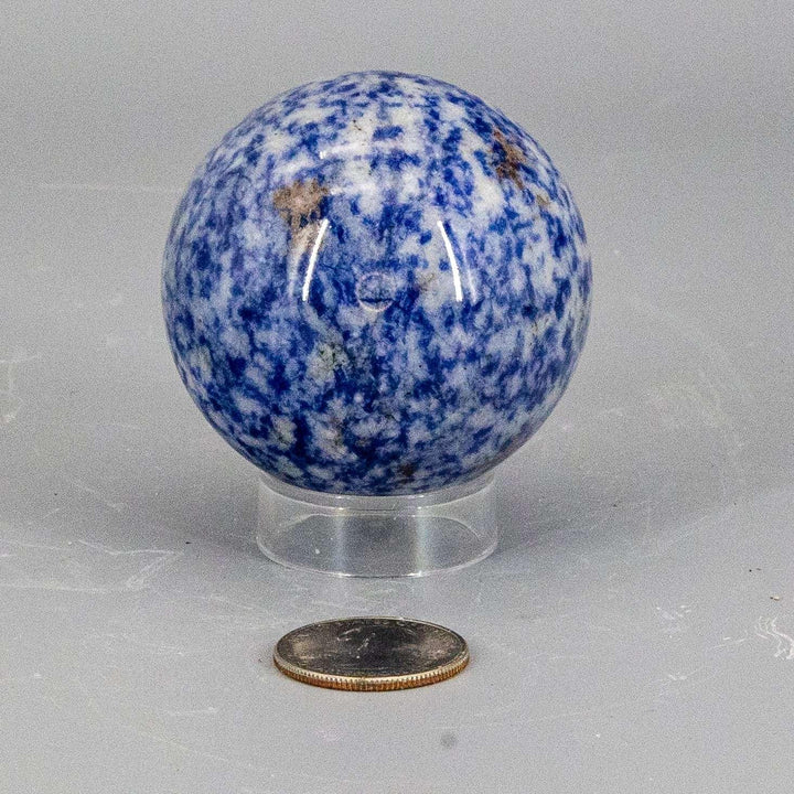 Sodalite Sphere 56mm: Deep blue crystal sphere with white calcite veining, a smooth, even polish, and a clear stand.