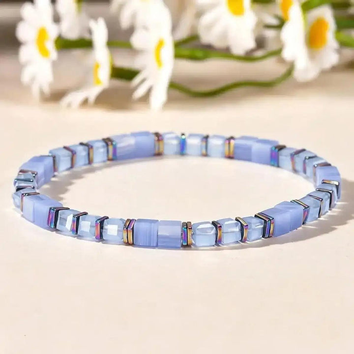 Sodalite cube bead bracelet with iridescent copper spacers for throat chakra clarity and elegant, geometric style.
