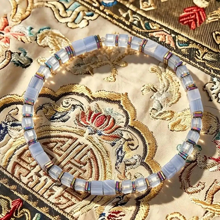 Sodalite cube bead bracelet featuring pale blue stones and iridescent copper spacers for throat chakra clarity.