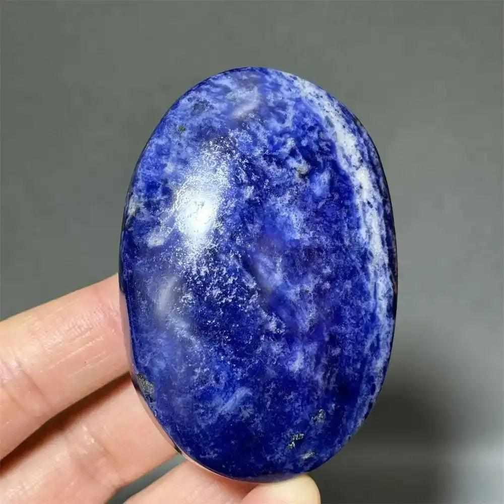 Polished Sodalite palm stone with deep blue hues and white veins, perfect for Throat Chakra reflection and meditation.