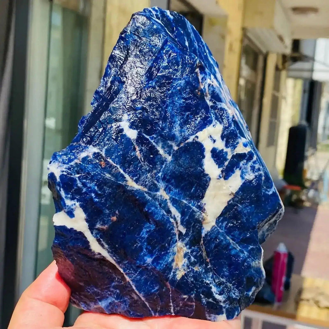 Large natural raw Sodalite crystal specimen featuring deep blue hues and white veining for healing and home decor.