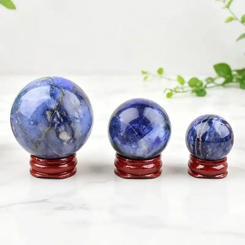 Polished blue sodalite spheres with unique mineral patterns, perfect for Throat Chakra healing and crystal displays.