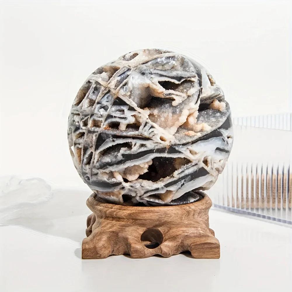 Gray & black Sphalerite crystal sphere with intricate patterns on a carved wooden stand.