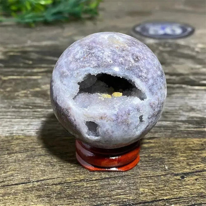 Polished Sphalerite sphere with metallic luster, rich amber tones, and flashes of brilliance on a display stand.