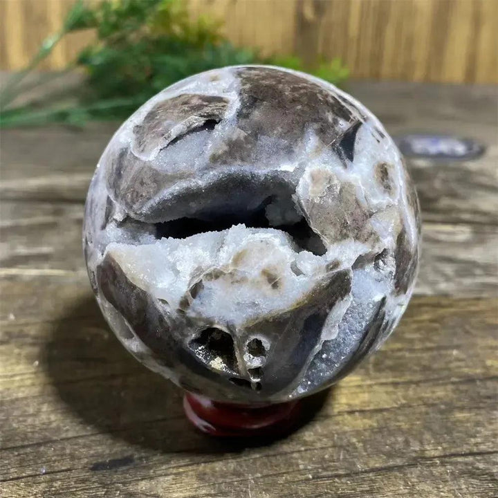 Polished Sphalerite sphere with metallic luster, rich amber to brown tones, and unique natural variations on a stand.