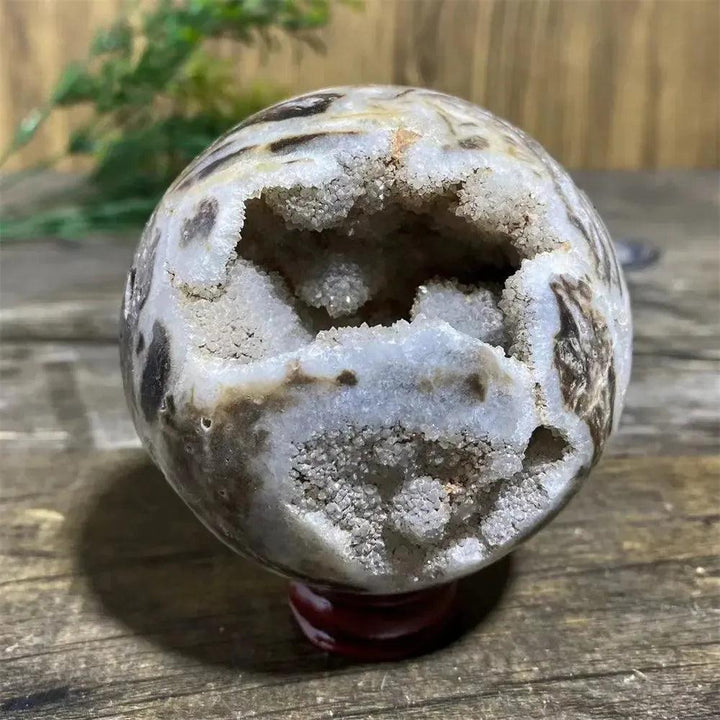 Sphalerite Geode Sphere with Stand, showcasing sparkling white crystals within a brown and white patterned stone.