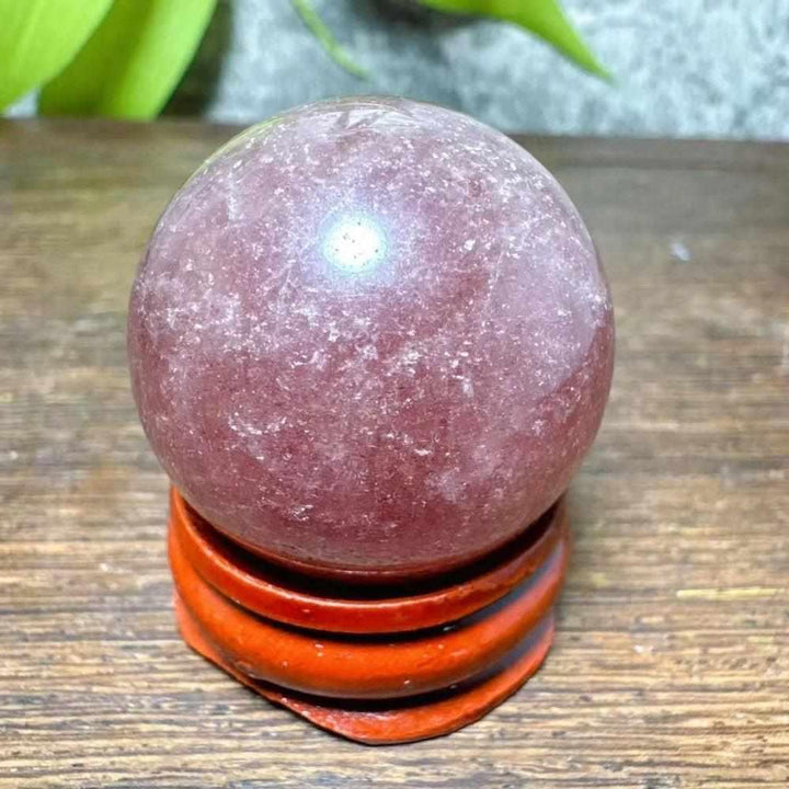 Polished 30-32mm Strawberry Quartz mini sphere featuring pink flecks and white snowflake clouds for heart chakra healing.