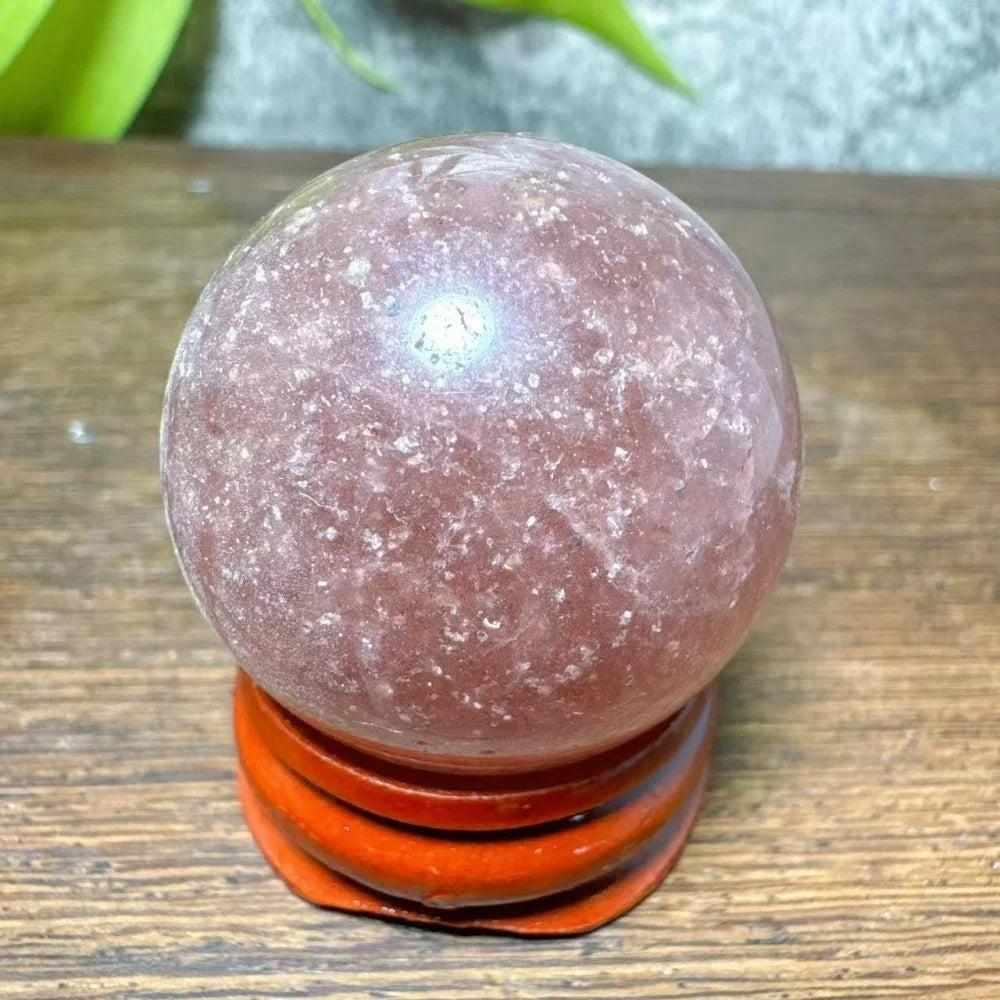 Polished 32mm Strawberry Quartz mini sphere featuring pink flecks and white snowflake clouds for heart chakra healing.