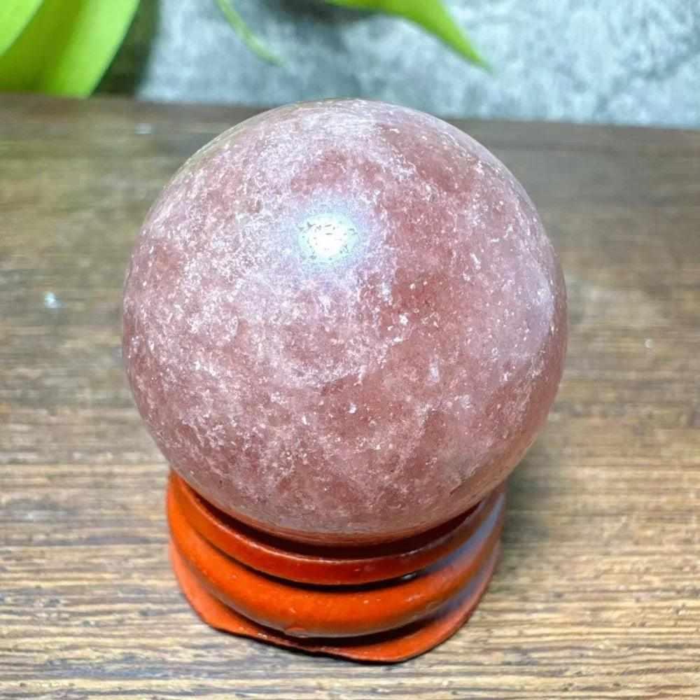 Polished 30-32mm Strawberry Quartz mini sphere featuring pink flecks and white snowflake clouds for heart chakra healing.
