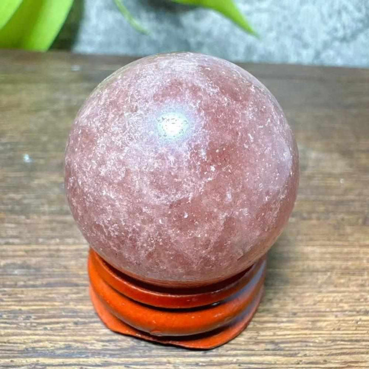 Polished 30-32mm Strawberry Quartz mini sphere featuring pink flecks and white snowflake clouds for heart chakra healing.
