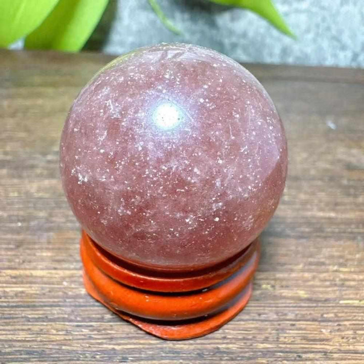 Polished 30-32mm Strawberry Quartz mini sphere featuring pink flecks and white snowflake clouds for heart chakra healing.