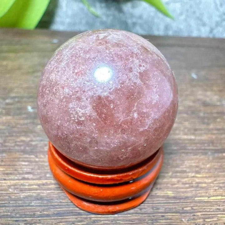 Polished 30mm Strawberry Quartz mini sphere featuring pink flecks and white snowflake clouds for heart chakra healing.