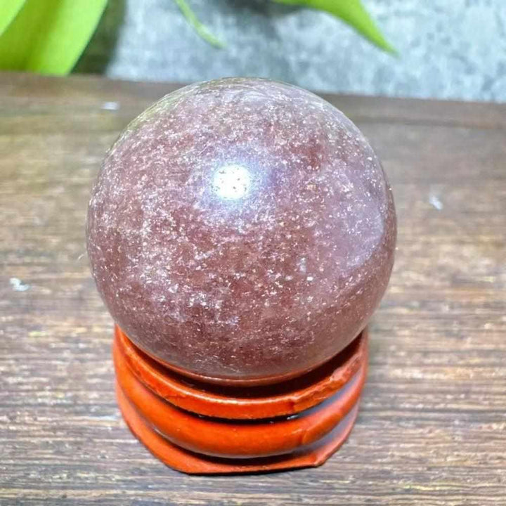 Polished 32mm Strawberry Quartz mini sphere featuring red, pink flecks and white snowflake clouds for heart chakra healing.