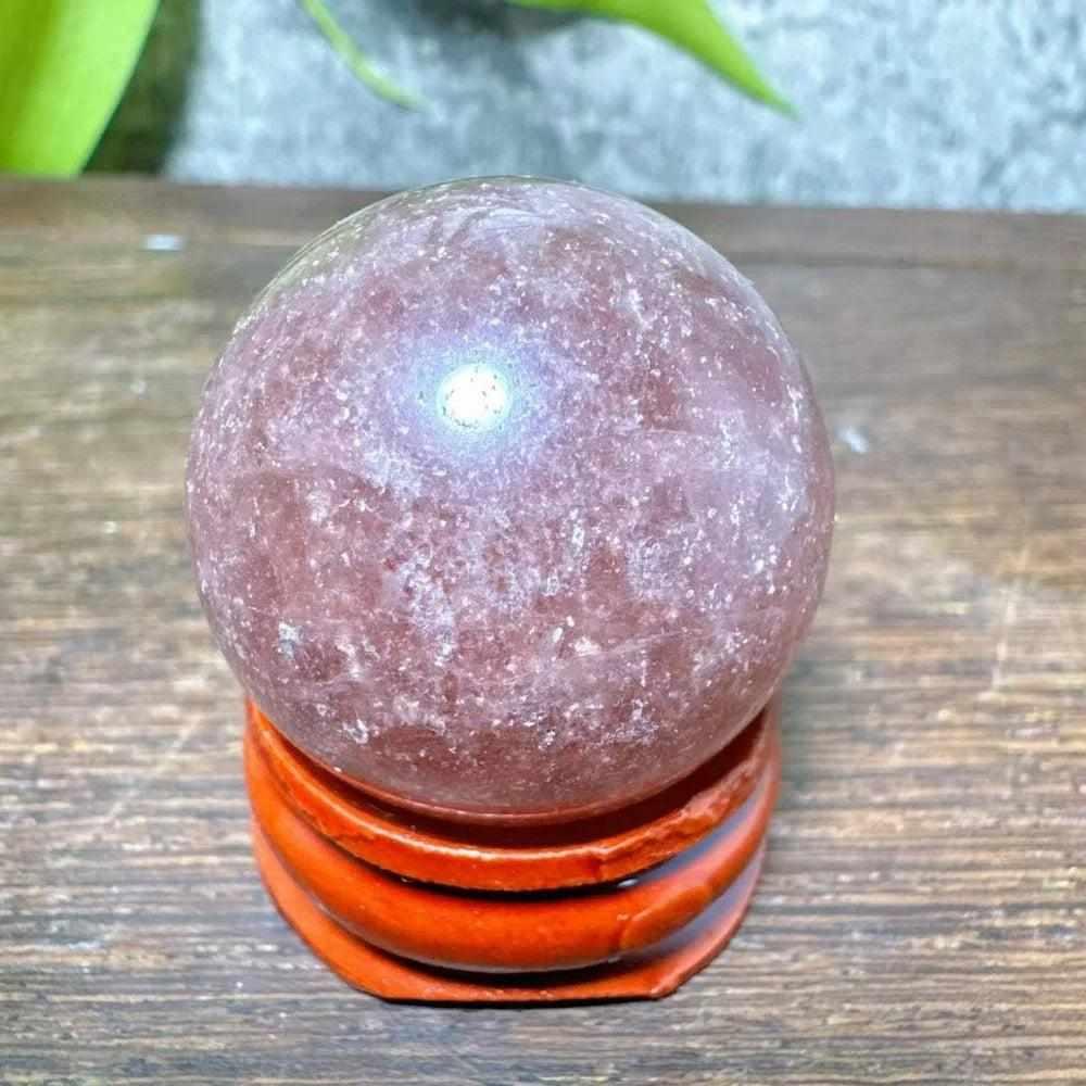 Polished 32mm Strawberry Quartz mini sphere featuring pink-red flecks and white snowflake clouds for heart chakra healing.