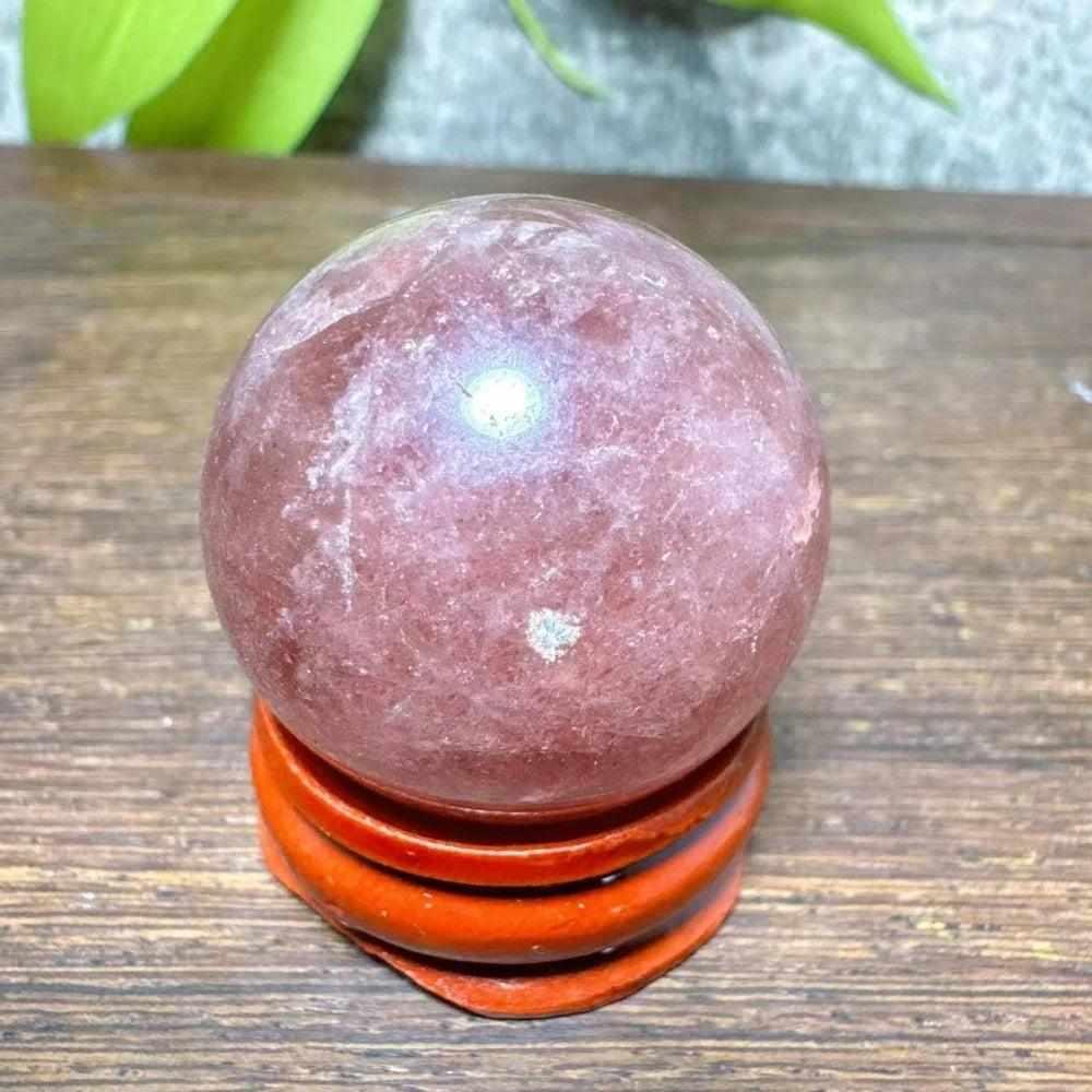 Polished 30mm Strawberry Quartz mini sphere featuring pink flecks and white snowflake clouds for heart chakra healing.