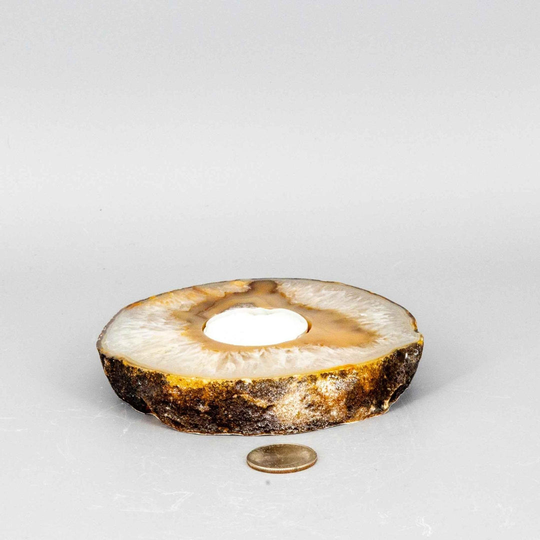 Thick, polished Agate slice tea light candle holder with natural banding and a white tea light.
