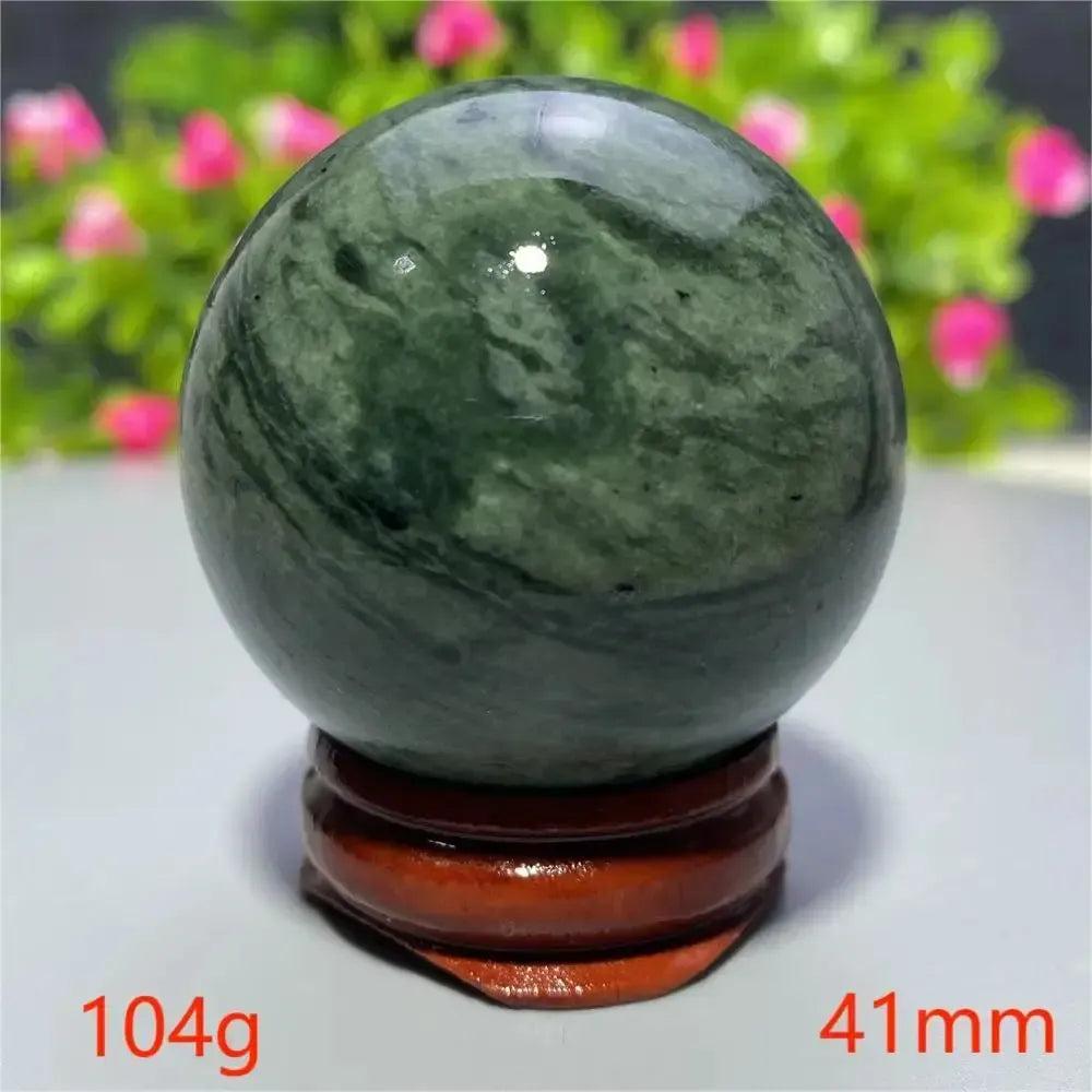 Smooth, polished dark green Tibetan Jade crystal sphere on a wooden stand from Crystal Destiny, 41mm, 104g.