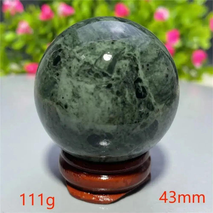 Smooth, polished dark green Tibetan Jade Crystal Sphere (43mm, 111g) on a wooden stand from Crystal Destiny.