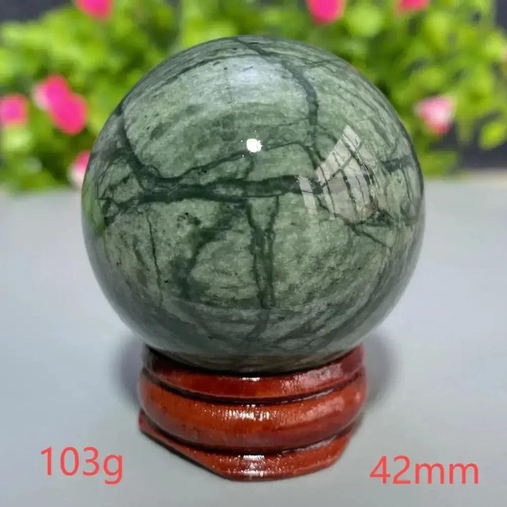 Polished green Tibetan Jade Crystal Sphere (42mm, 103g) on a wooden stand from Crystal Destiny.
