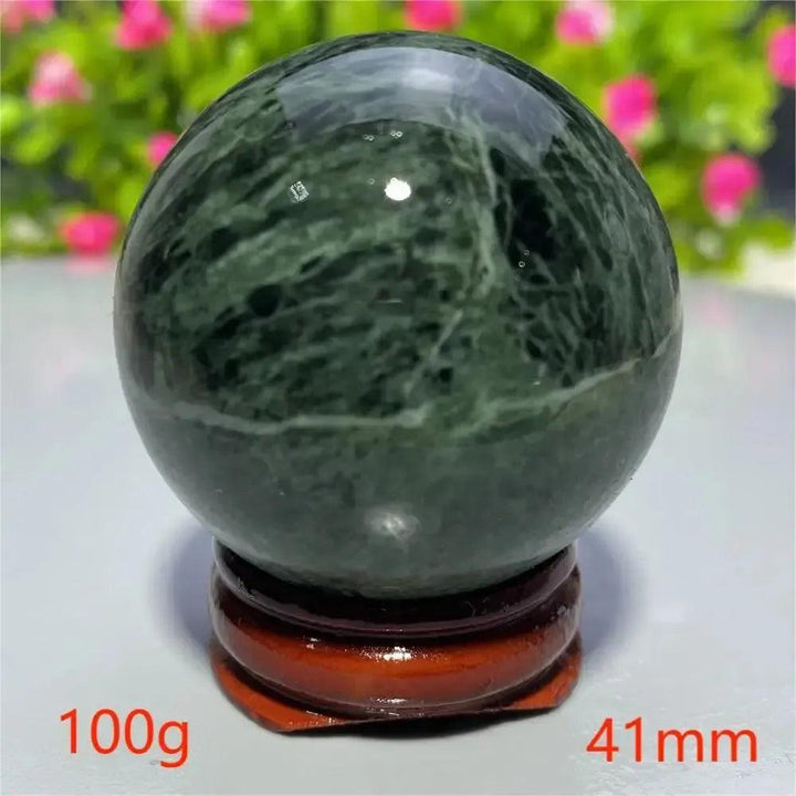 Polished dark green Tibetan Jade Crystal Sphere from Crystal Destiny, 100g, 41mm, on a wooden stand.