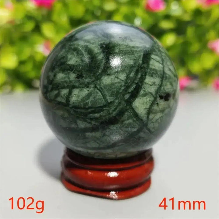 Polished dark green Tibetan Jade Crystal Sphere with natural patterns on a red stand, 41mm, from Crystal Destiny.