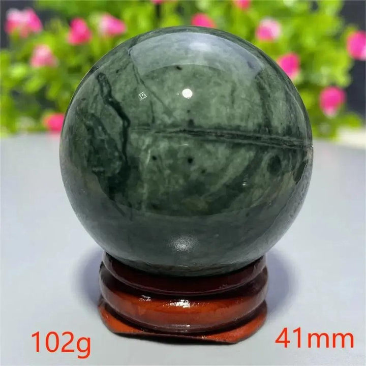 Polished dark green Tibetan Jade crystal sphere on a wooden stand, 102g, 41mm, from Crystal Destiny.