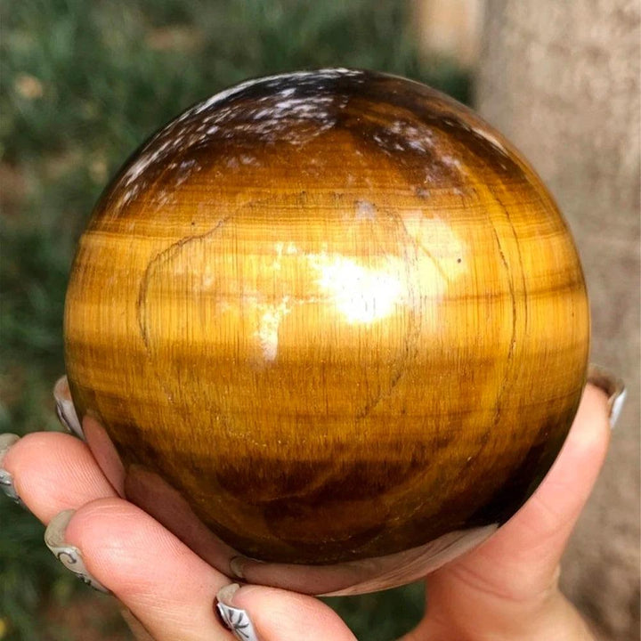 Polished natural Tiger Eye crystal sphere with golden-brown bands, perfect for Reiki healing and elegant home decor.