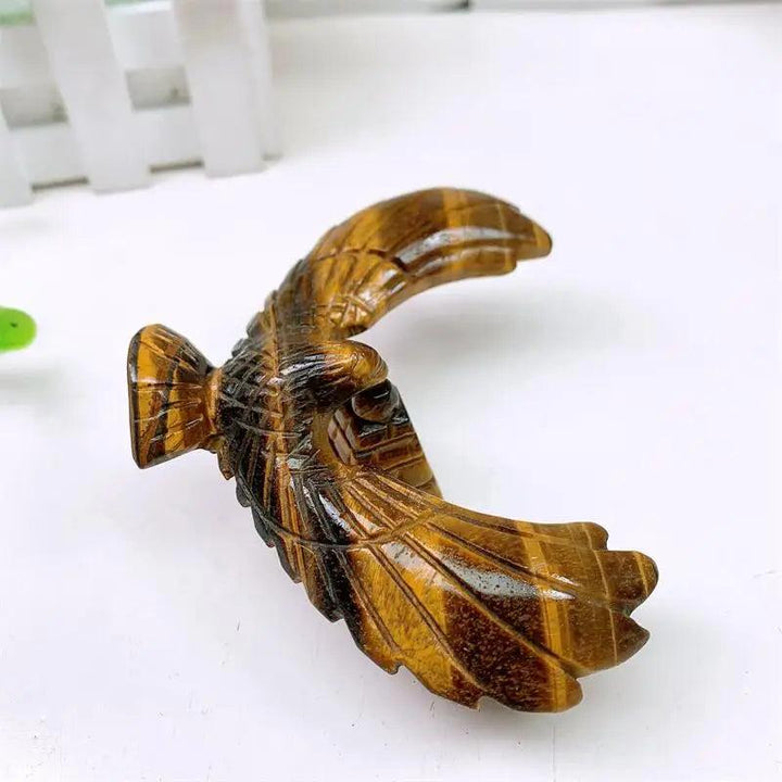 Hand-carved Tiger Eye spinning eagle statue with golden chatoyant bands for grounding, stability, and mindful focus.