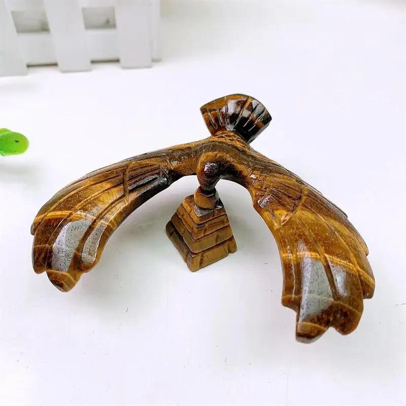 Hand-carved Tiger Eye spinning eagle statue on a pyramid base, featuring golden chatoyant bands for grounding energy.